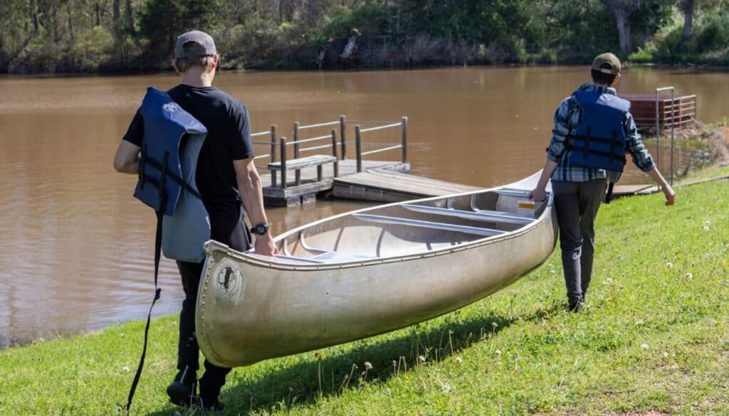 Children at a summer camp participate in outdoor activities like ziplining and kayaking to build confidence and social skills.
